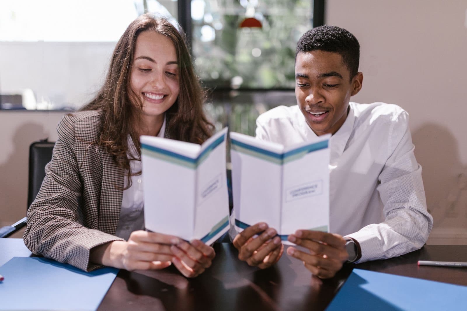 Twee professionals bespreken samen documenten in een licht kantoor